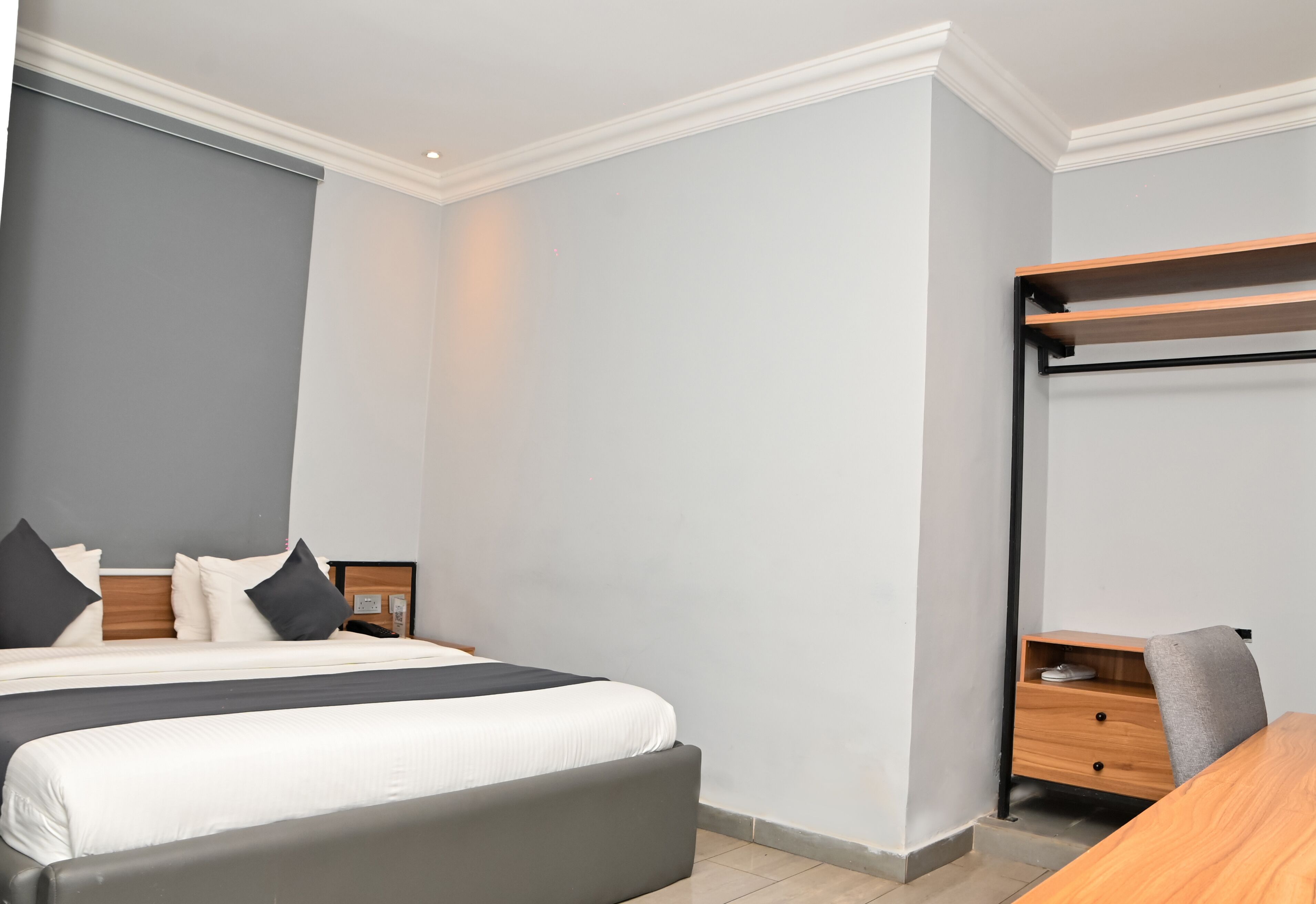 A bedroom with a bed, bedside tables, a desk, and a chair.