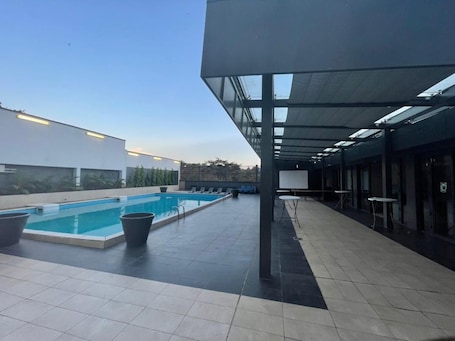 Una piscina al aire libre, sillones reclinables de piscina