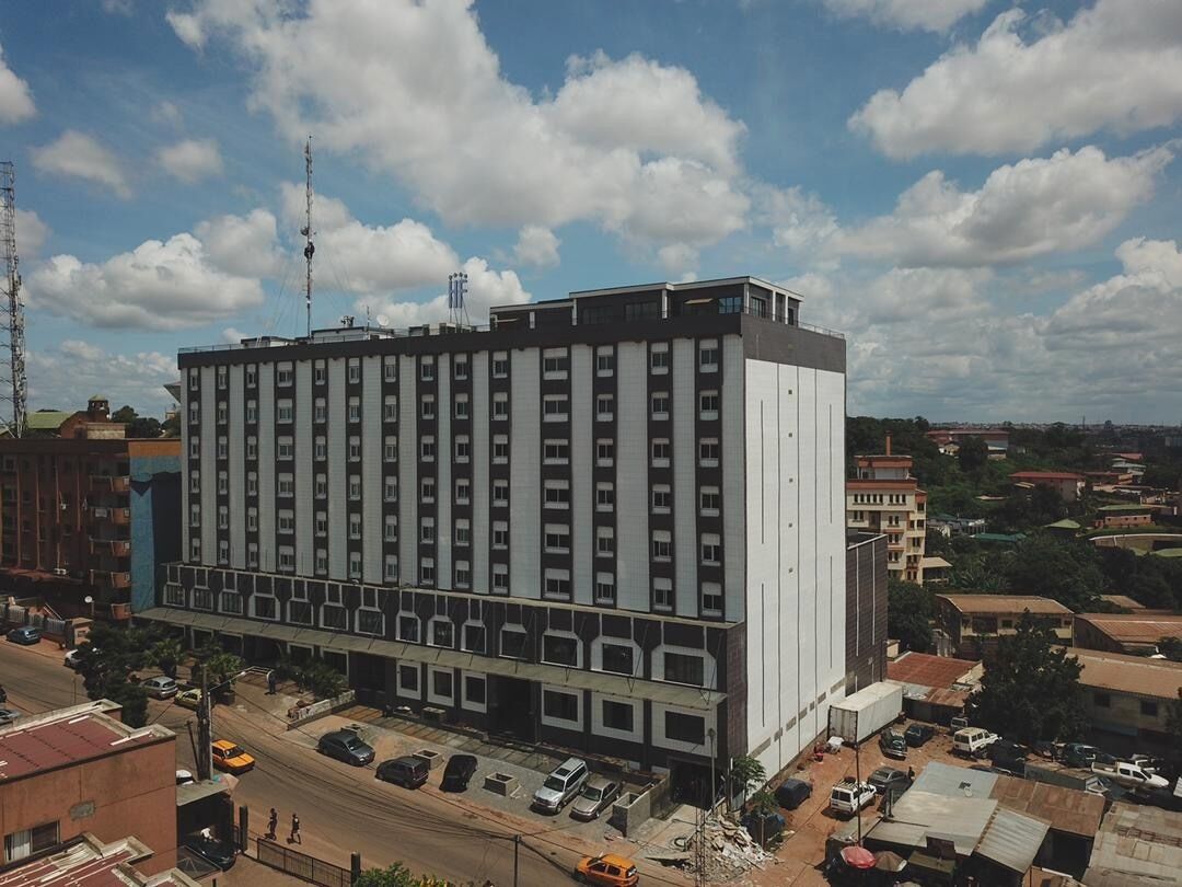 Un hôtel à plusieurs étages doté d’une architecture moderne, caractérisé par un toit plat et une série de fenêtres à chaque étage.
