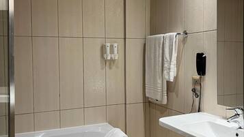 Un baño moderno con bañera, lavamanos y espejo.