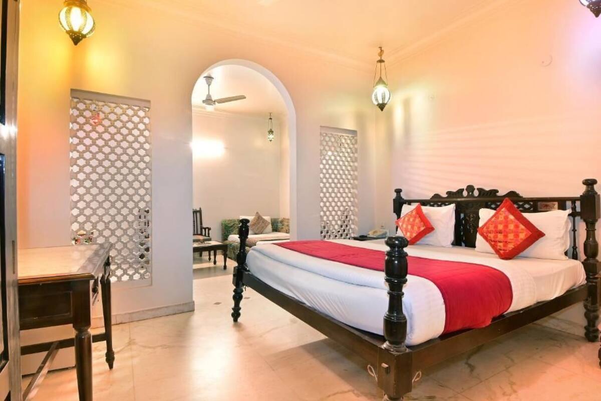 A bedroom with a large bed, a desk, and a chair.