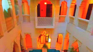 A courtyard with a central pool, surrounded by white buildings with arches and balconies. - Jyoti Mahal A Royal Heritage Hotel - 5 Mins from New Delhi Railway station & 2Mins From Metro (New Delhi)