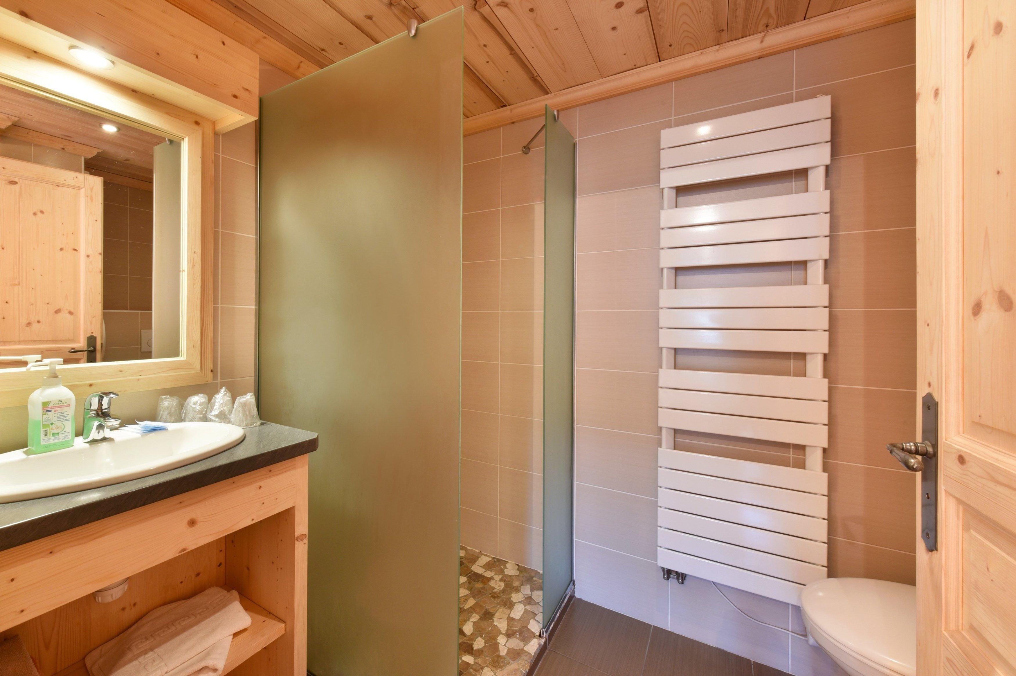 A bathroom with a wooden vanity, a sink, and a toilet.