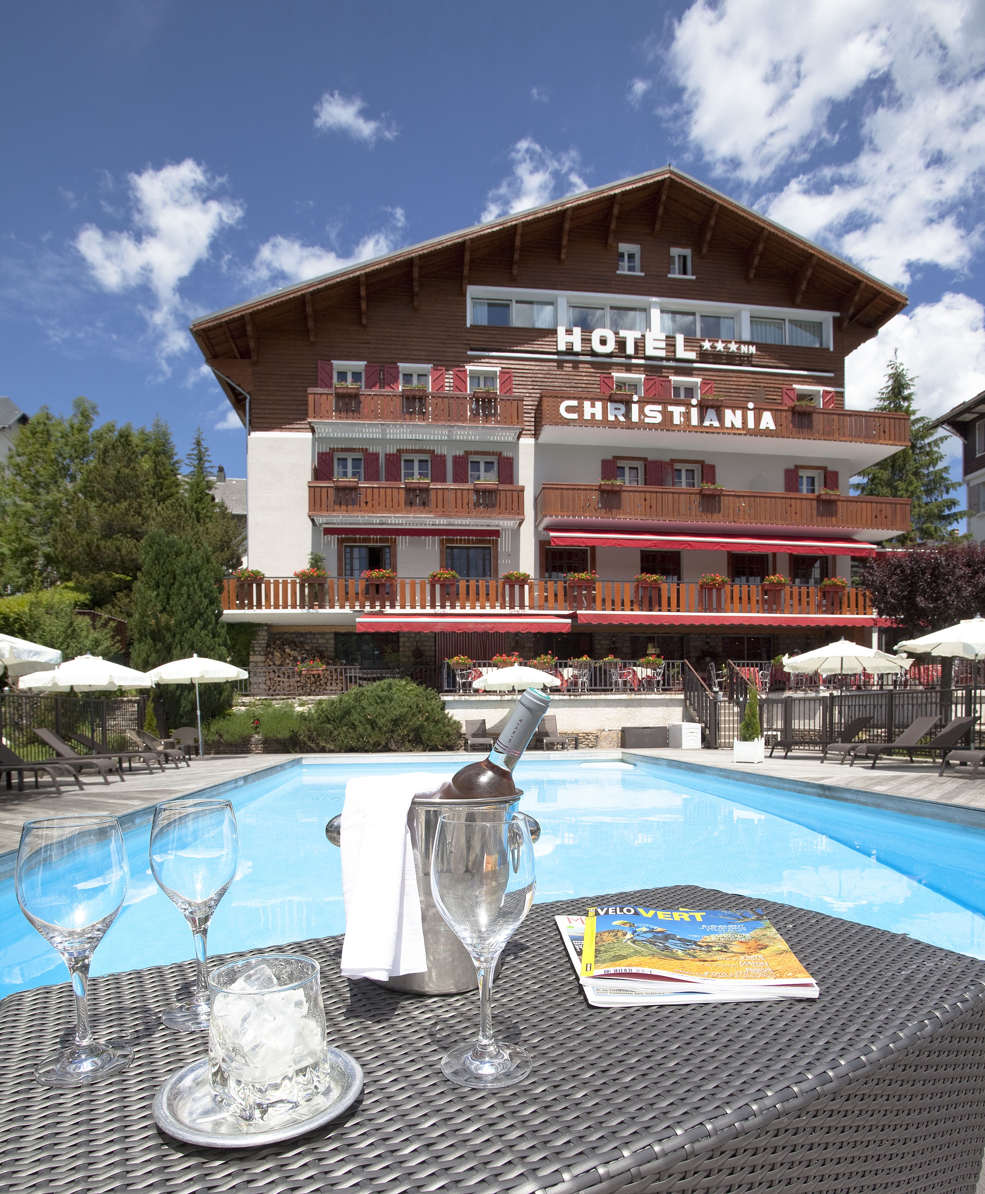 Een hotel met een zwembad, terras en een menukaart op de tafel.