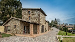 A stone building with a tiled entrance and a paved pathway leading to it.