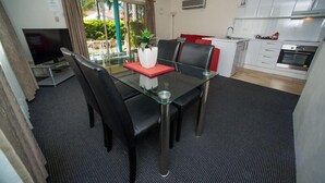Un espacio habitable compacto con comedor, cocina y televisor.