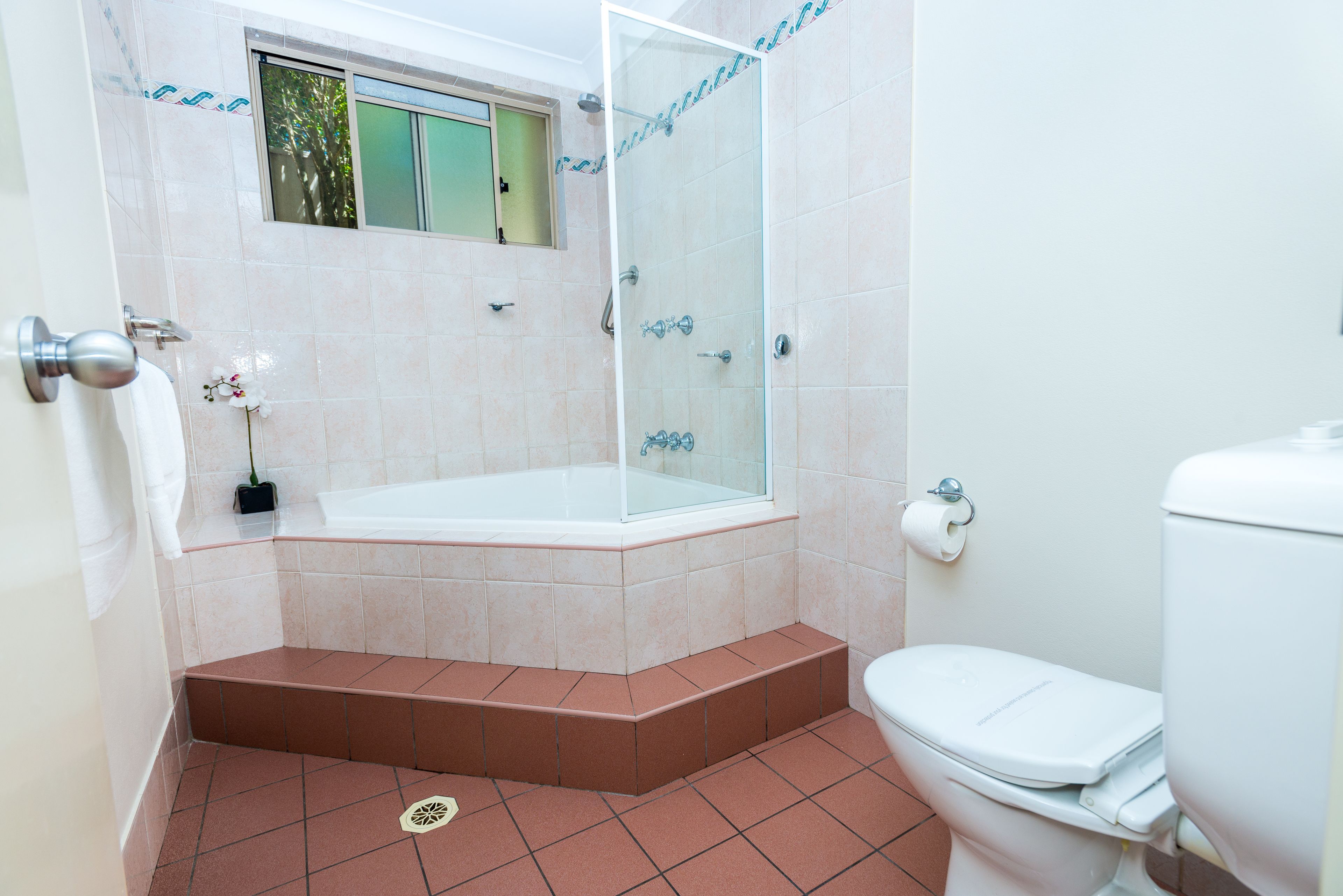 A bathroom with a bathtub, toilet, and a shower enclosure.