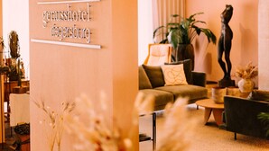 A hotel lobby with a sign reading "genusshotel negersburg." There are sofas, a coffee table, and decorative plants. - Genusshotel Riegersburg (Riegersburg)