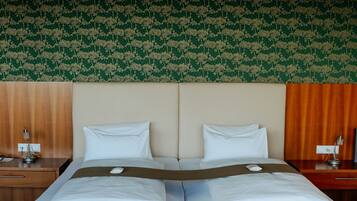 A double bed with a wooden frame, two pillows, and a brown blanket.