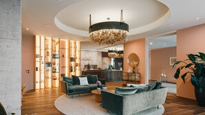 A modern living room with a sofa set, a round coffee table, and a chandelier. - Genusshotel Riegersburg (Riegersburg)