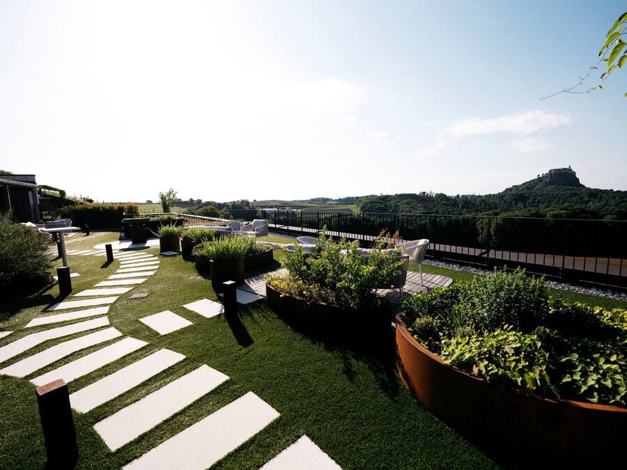 Eine Dachterrasse mit Blick auf einen Hügel und eine Burg.