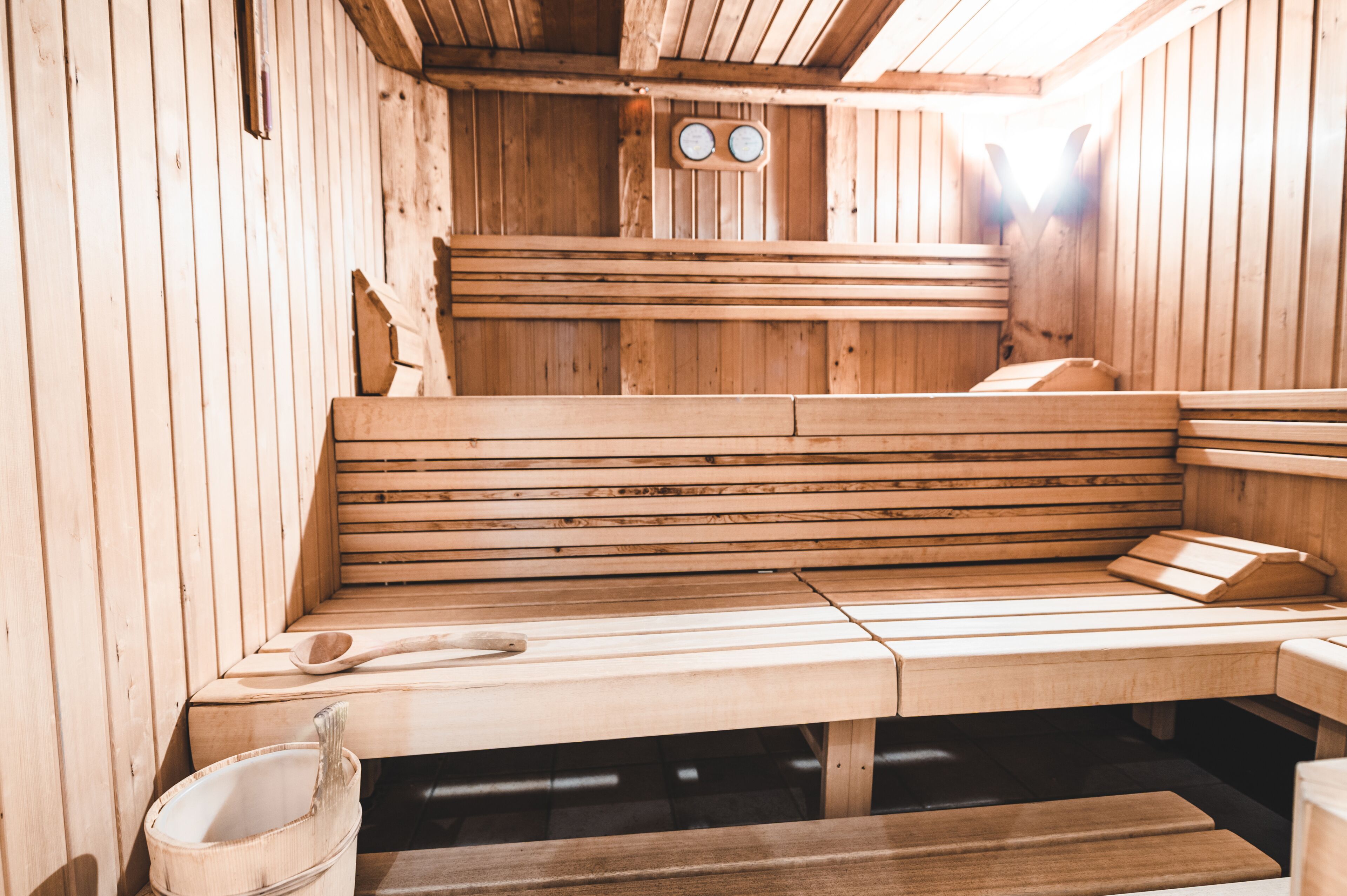 A wooden sauna with benches and a wooden spoon.