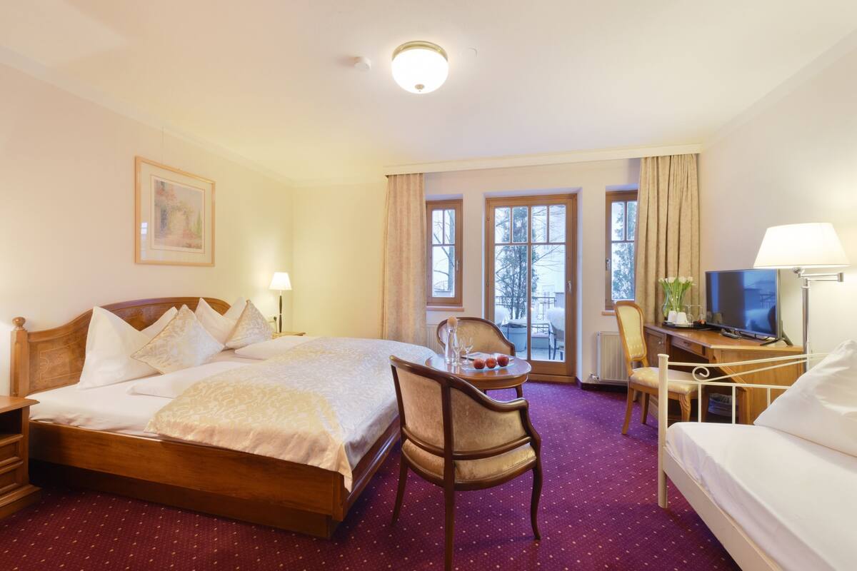 Une chambre d’hôtel comprenant un lit, un bureau avec un ordinateur, une chaise et un téléviseur.