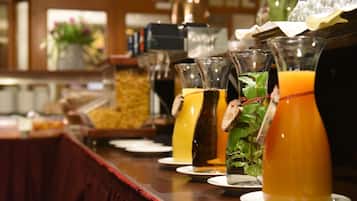 Zona de bar con diversas bebidas y un bufé al fondo.