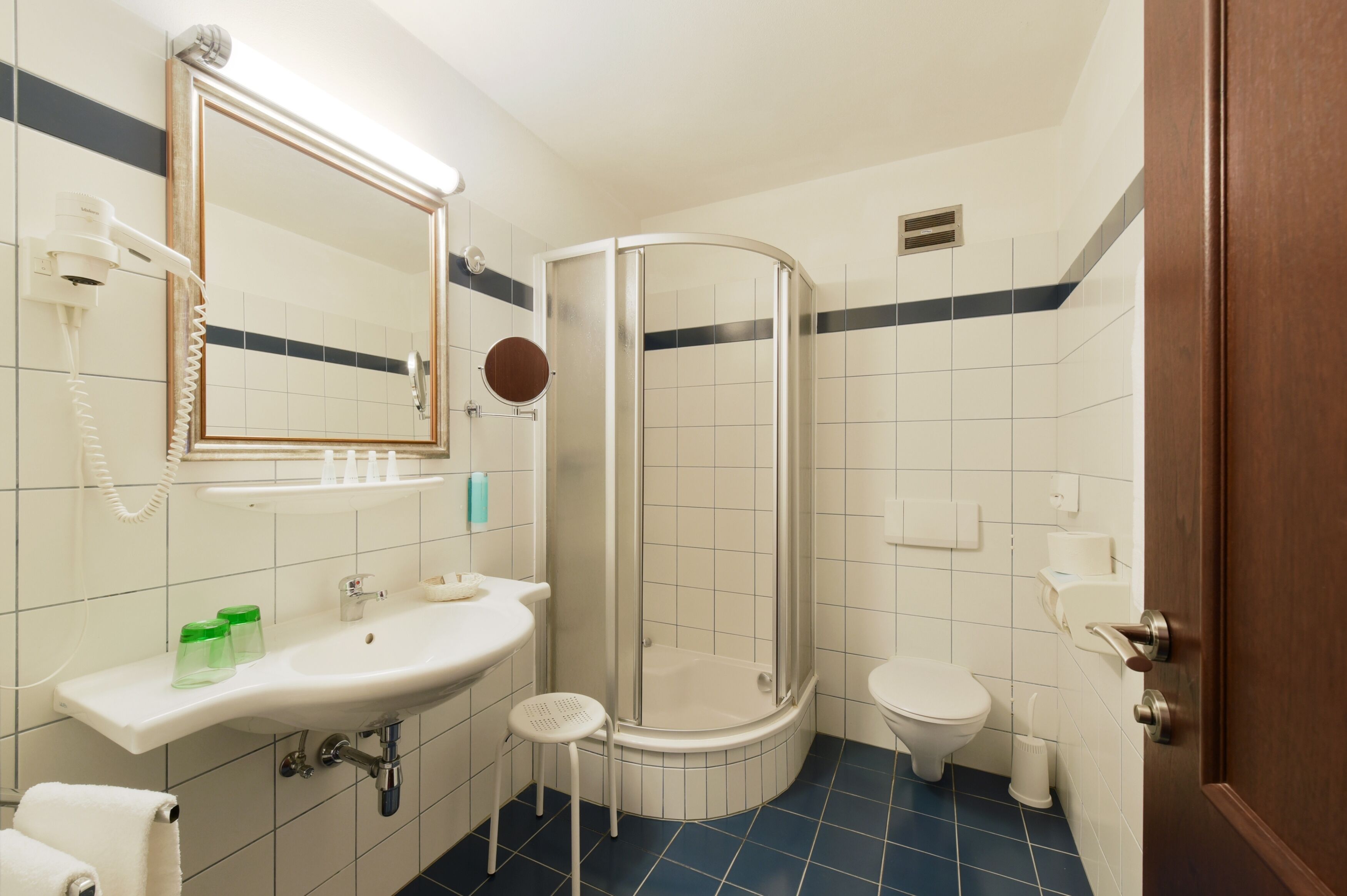 Ein Badezimmer mit Waschbecken, Spiegel, Toilette und Dusche.