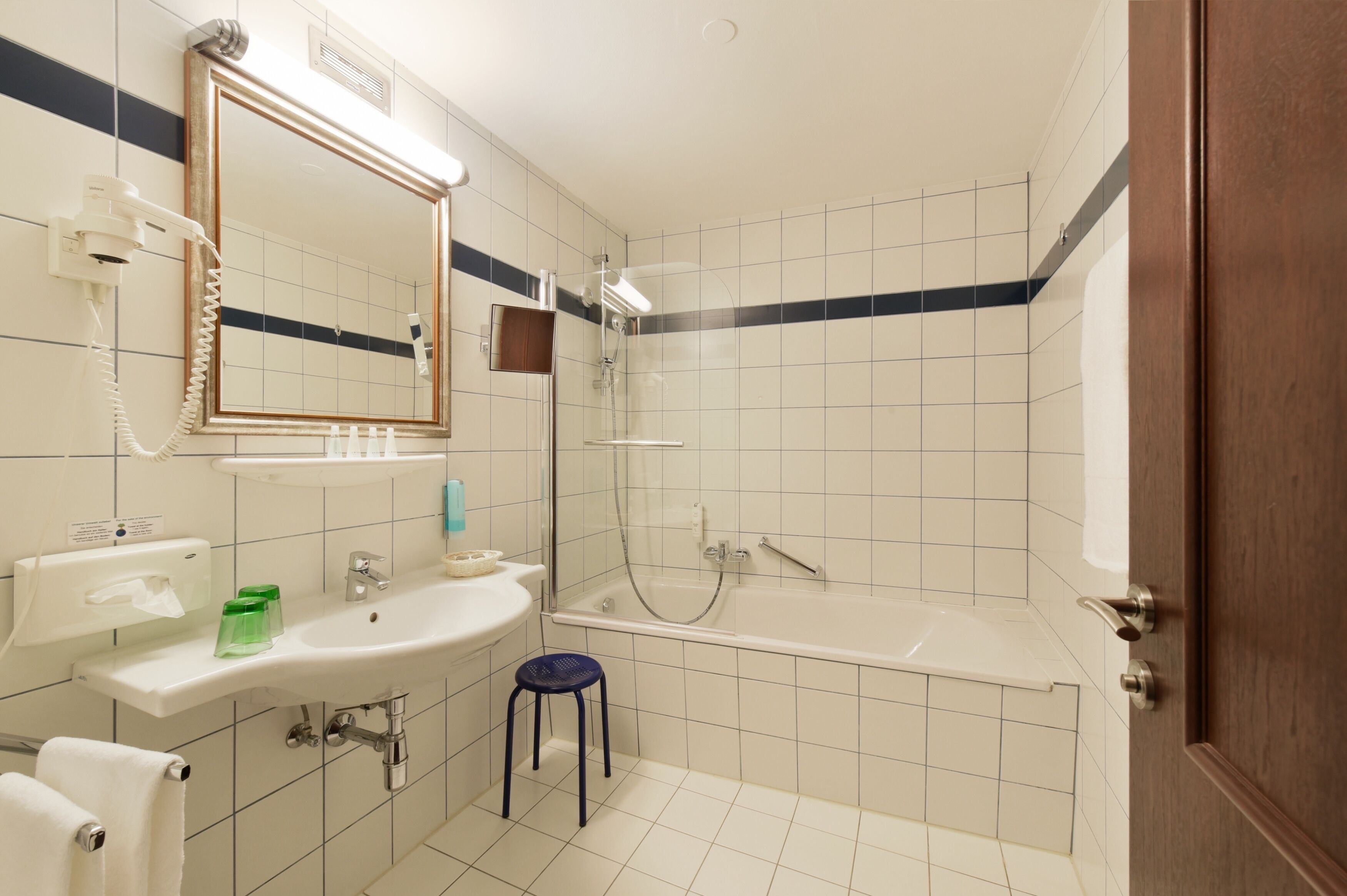 A bathroom with a sink, mirror, and shower.