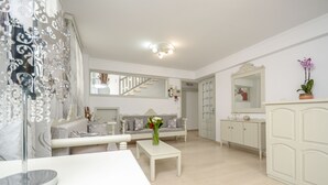 A spacious living room with a white sofa, a coffee table, and a mirror. - Golden Beach Studios (Naxos)