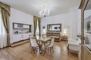 A modern living room with a dining area, a kitchen, and a large mirror. - Al Bailo di Venezia Apartments (Venice)