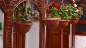 Una estructura de madera con múltiples macetas colgantes llenas de flores.