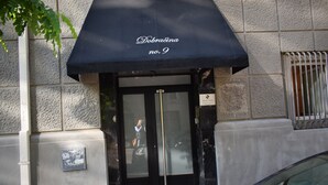Ein Gebäudeeingang mit einer schwarzen Markise, auf der "Dobraćina no. 9" steht.