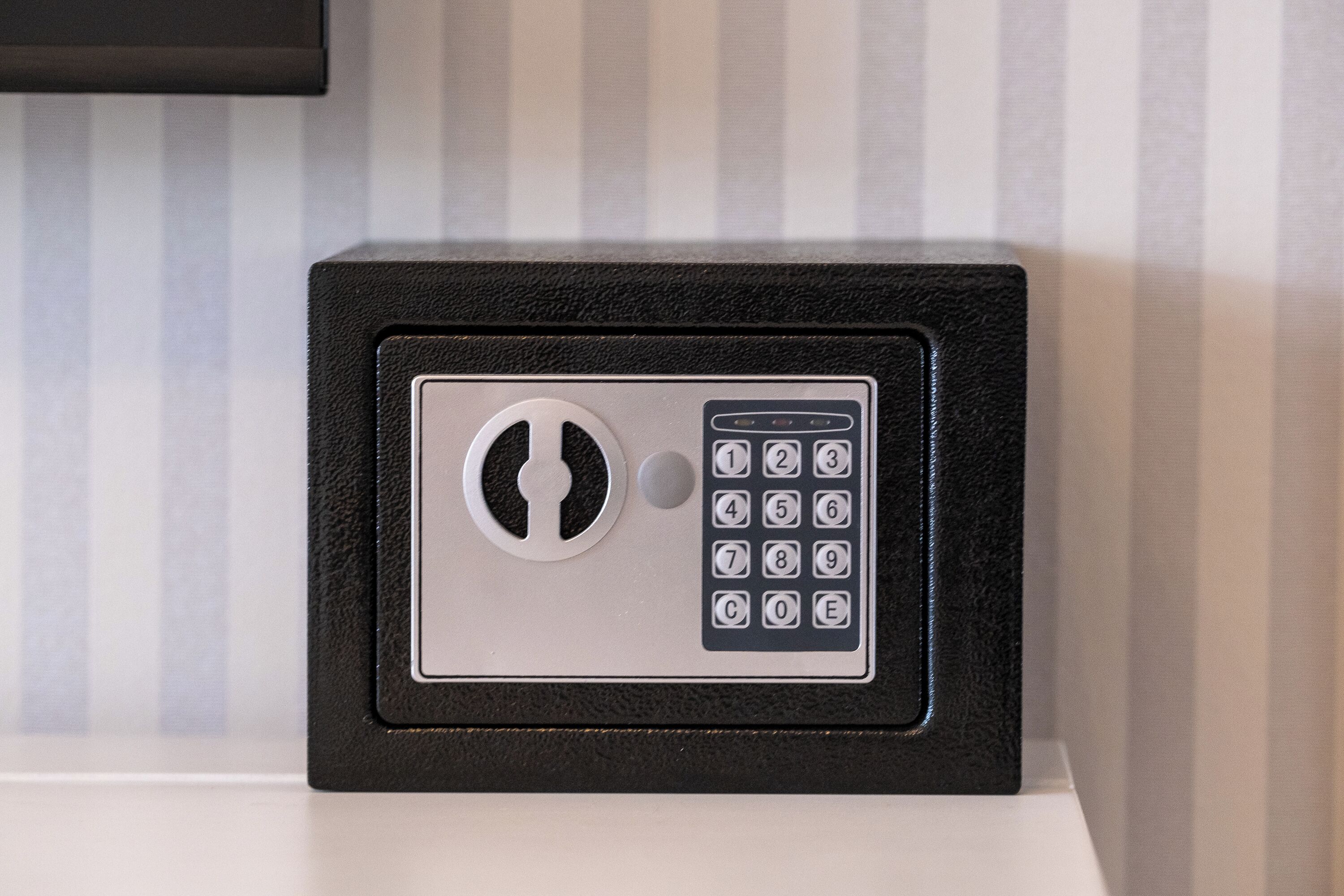 A black safe with a keypad and a keyhole.