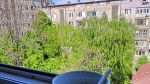 Eine Tasse Tee auf einem Fensterbrett mit Blick auf Gebäude und Bäume.