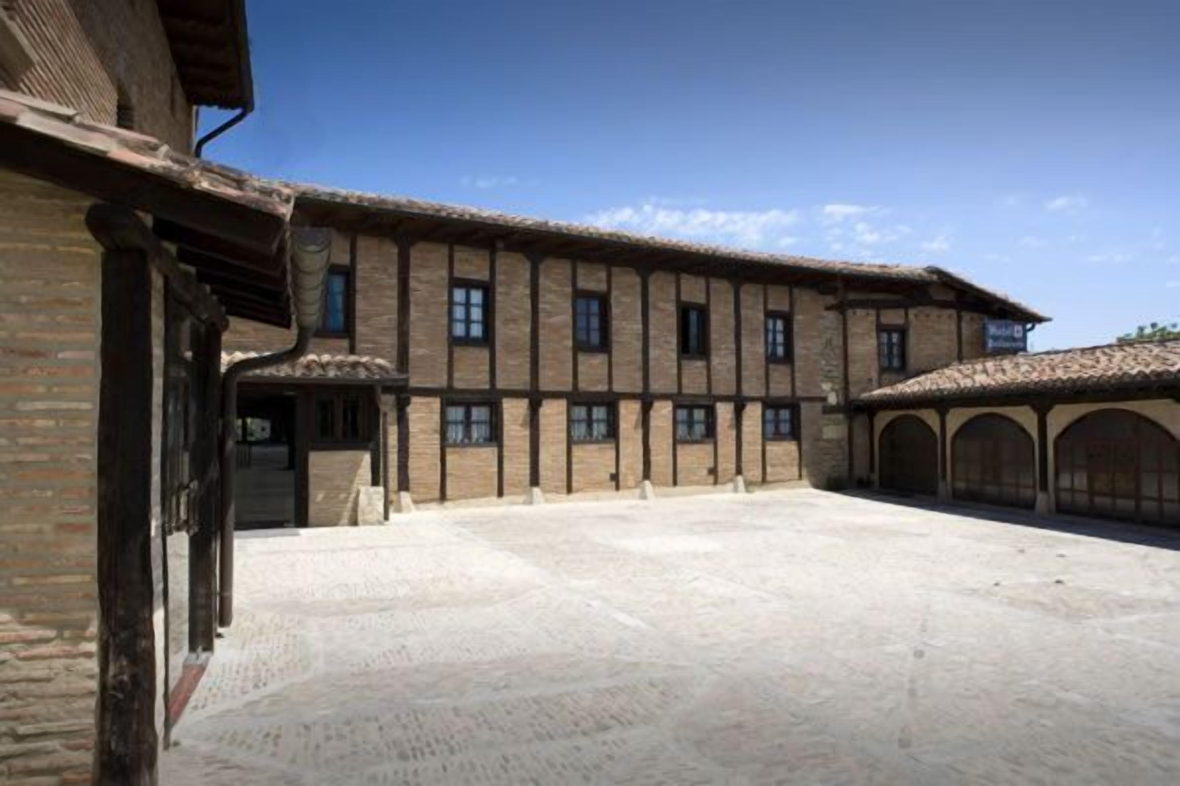 Un bâtiment doté d’une cour intérieure, avec une façade en briques et de nombreuses fenêtres.