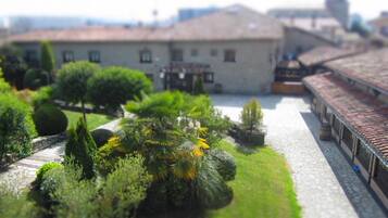 A model of a building with a courtyard, surrounded by various model trees and shrubs.