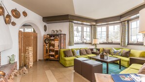 Un salon chaleureux avec un canapé vert, des meubles en bois et une cheminée.