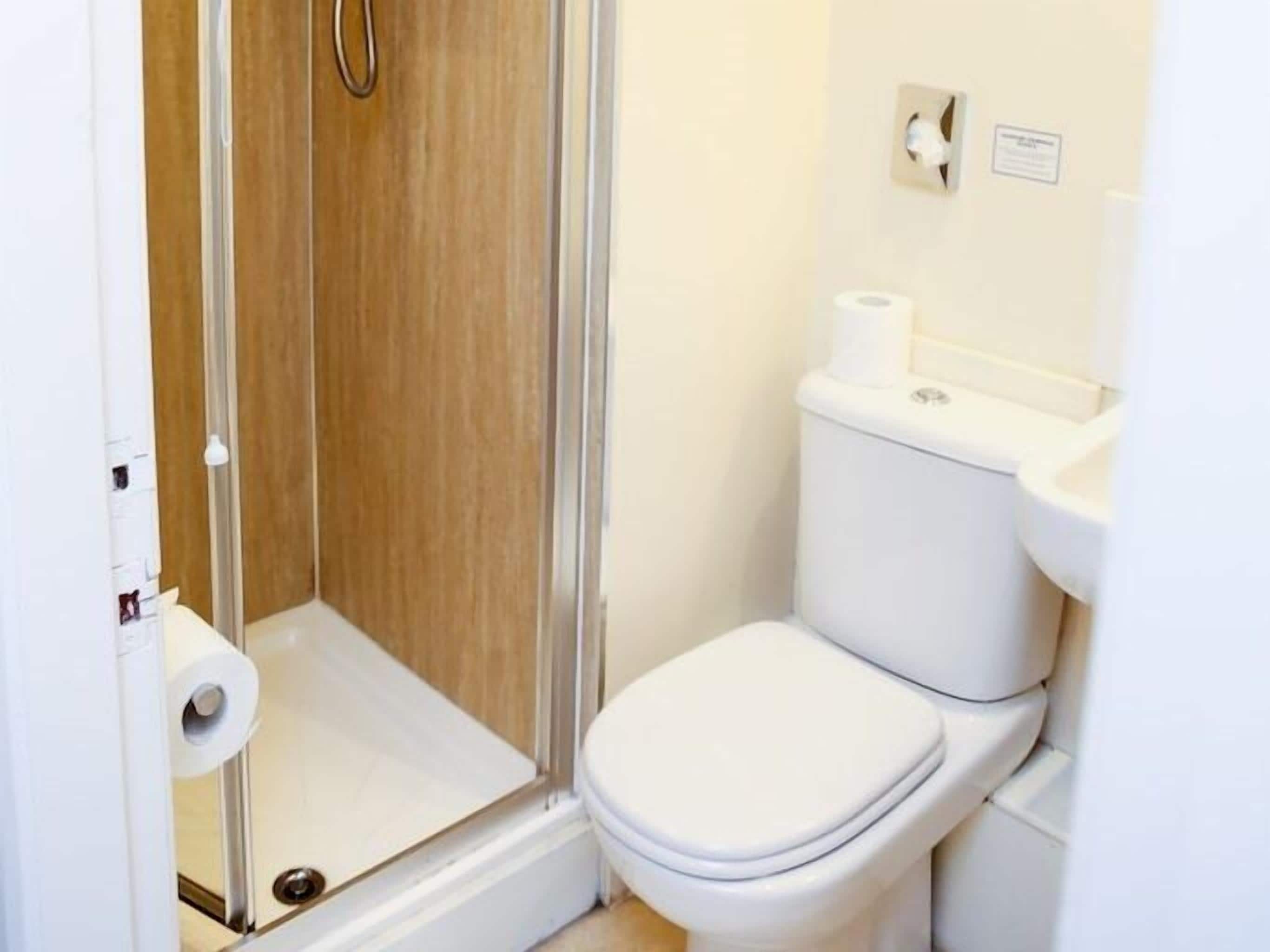 Une salle de bain équipée d’une douche, de toilettes et d’un lavabo.