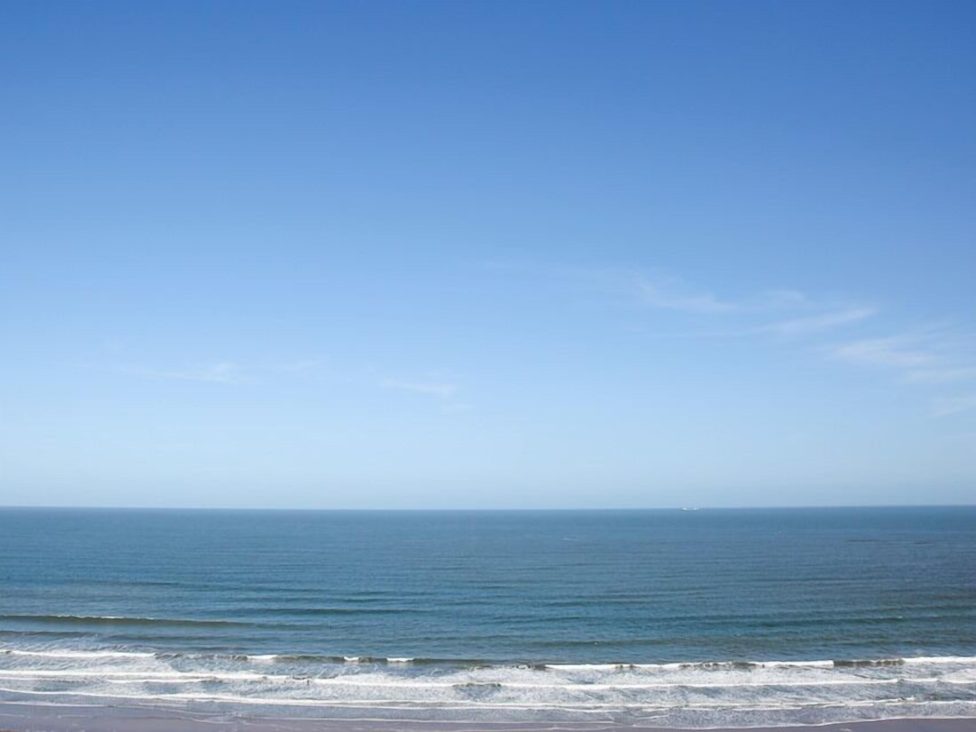 A beach with clear skies and calm sea.