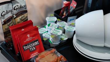 A breakfast tray with instant hot chocolate, Yorkshire tea, milk, yogurt, and croissants.
