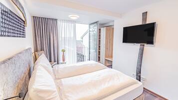 Een hotelkamer met een bed, een aan de muur bevestigde televisie en uitzicht door het raam.