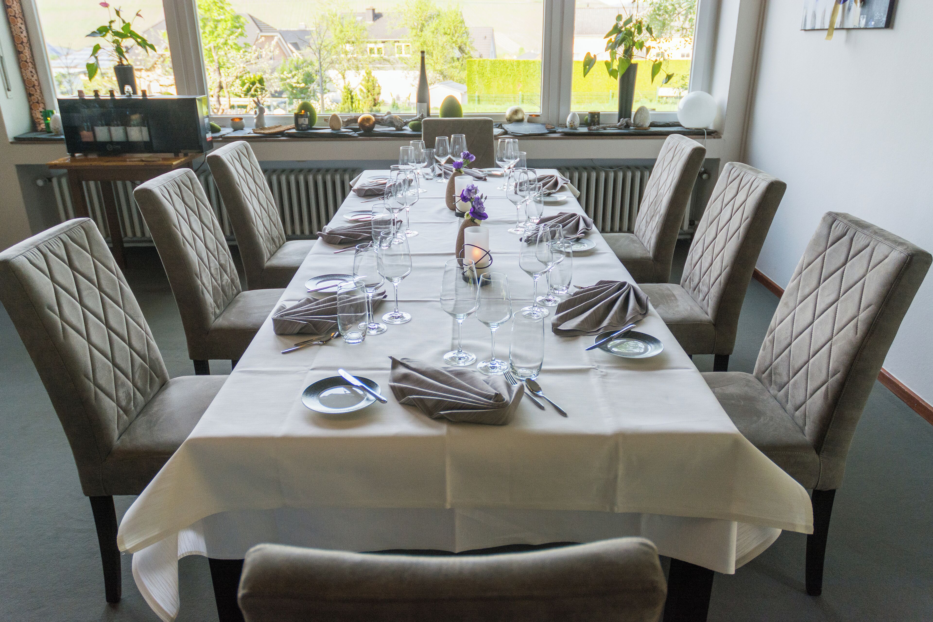 A dining table set for six with a view of the outdoors.