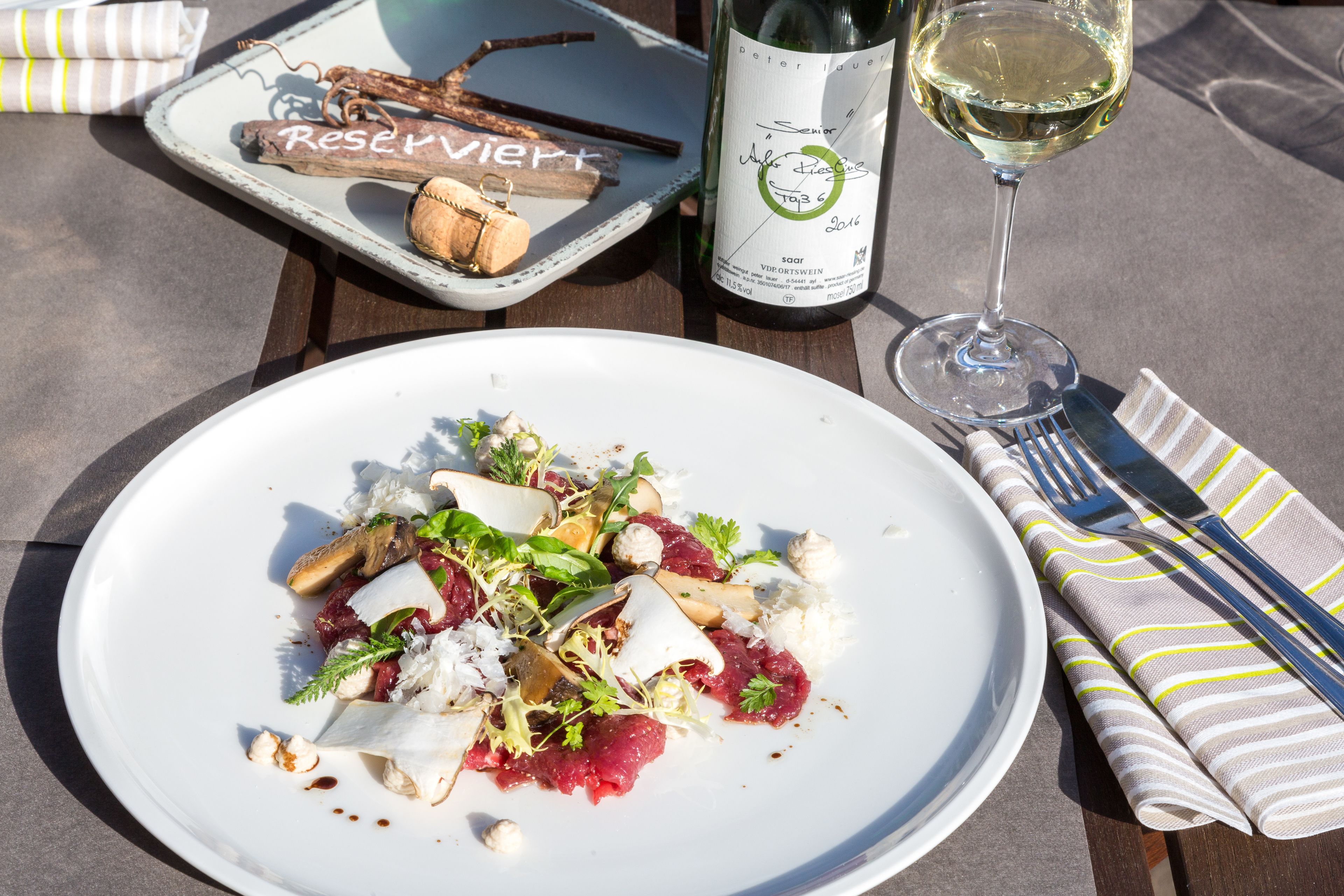 Une assiette de nourriture, une bouteille de vin et un verre de vin, le tout posé sur une table.
