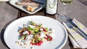 Une assiette de nourriture, une bouteille de vin et un verre de vin, le tout posé sur une table.