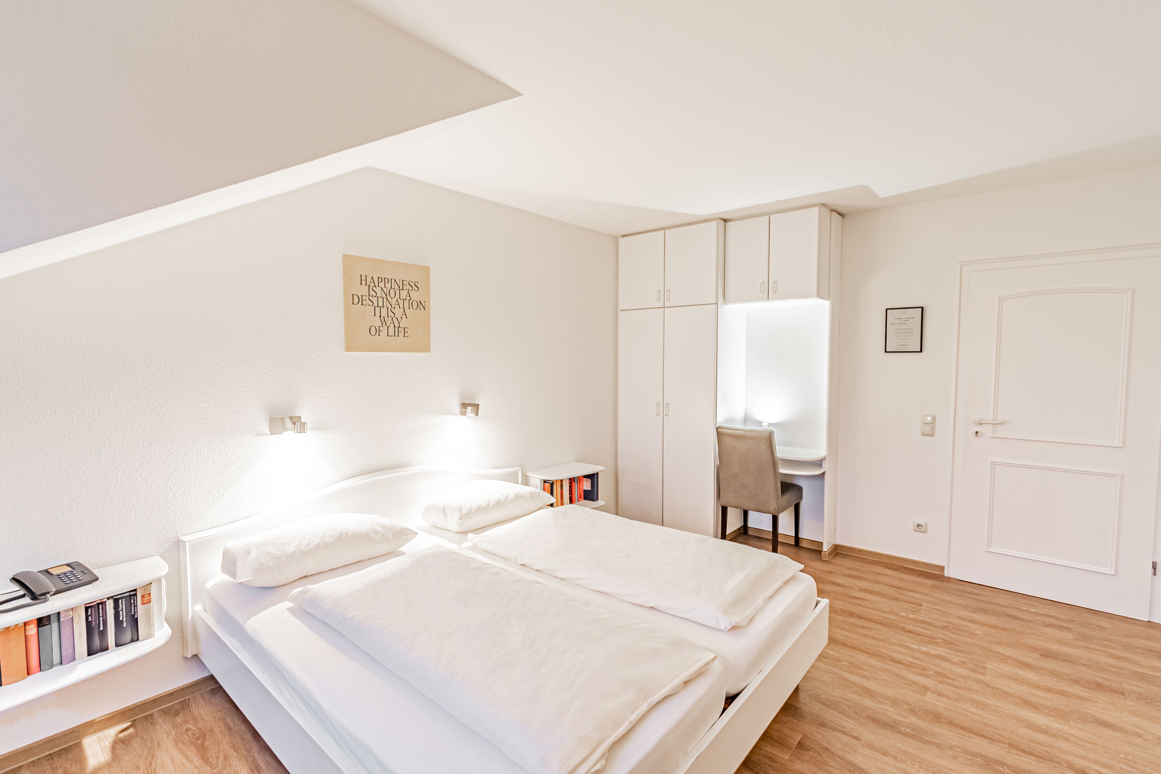 Une chambre avec deux lits, un bureau et une armoire.