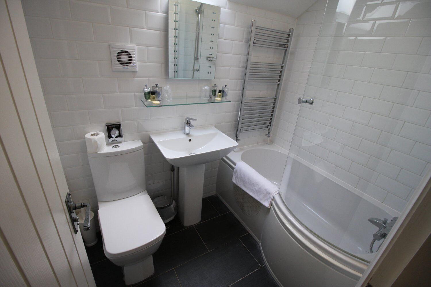 A compact bathroom with a toilet, sink, and bathtub.