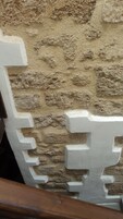 A textured wall with a white decorative element.