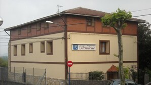 Un immeuble de deux étages sur lequel on peut lire l’inscription : « Pension Paratene ».