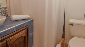 A bathroom with a toilet, a sink, and a shower curtain.
