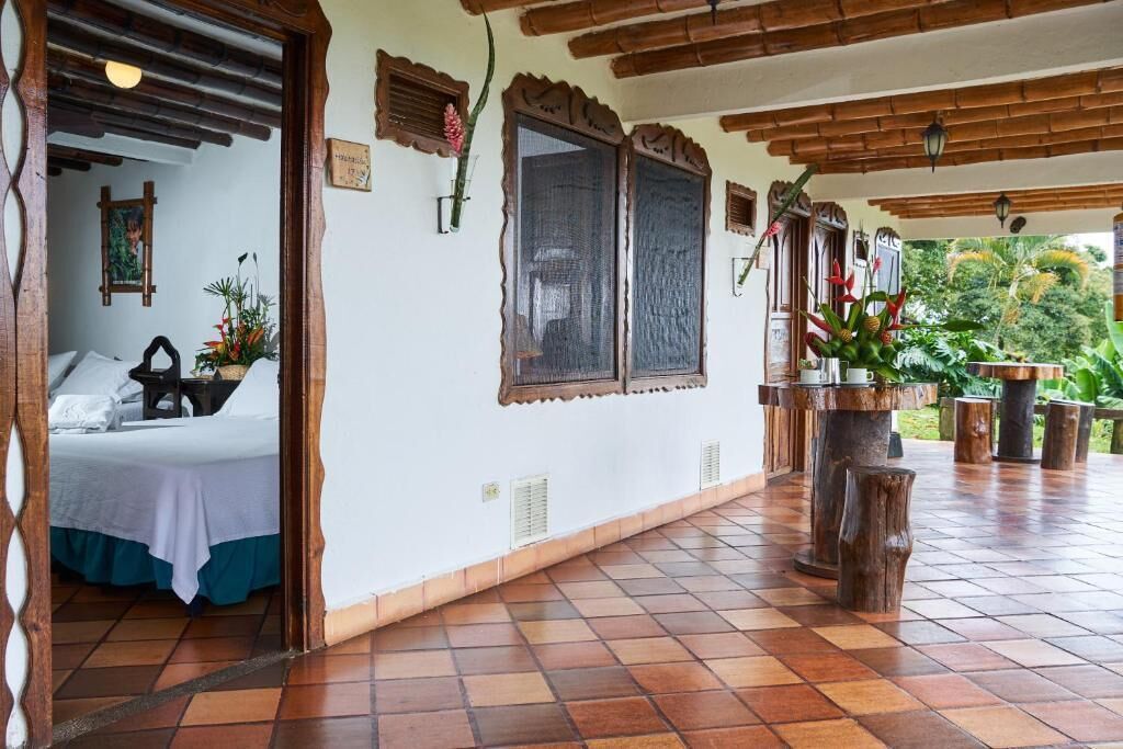 A room with a bed, a wooden ceiling, and a tiled floor.