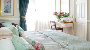 Un dormitorio con cama, escritorio, silla, cómoda y espejo.