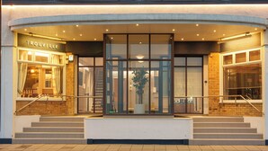 A hotel entrance with a glass facade, steps leading up to the door, and a sign reading "TROUVILLE". - Trouville Hotel by Compass Hospitality (Sandown)