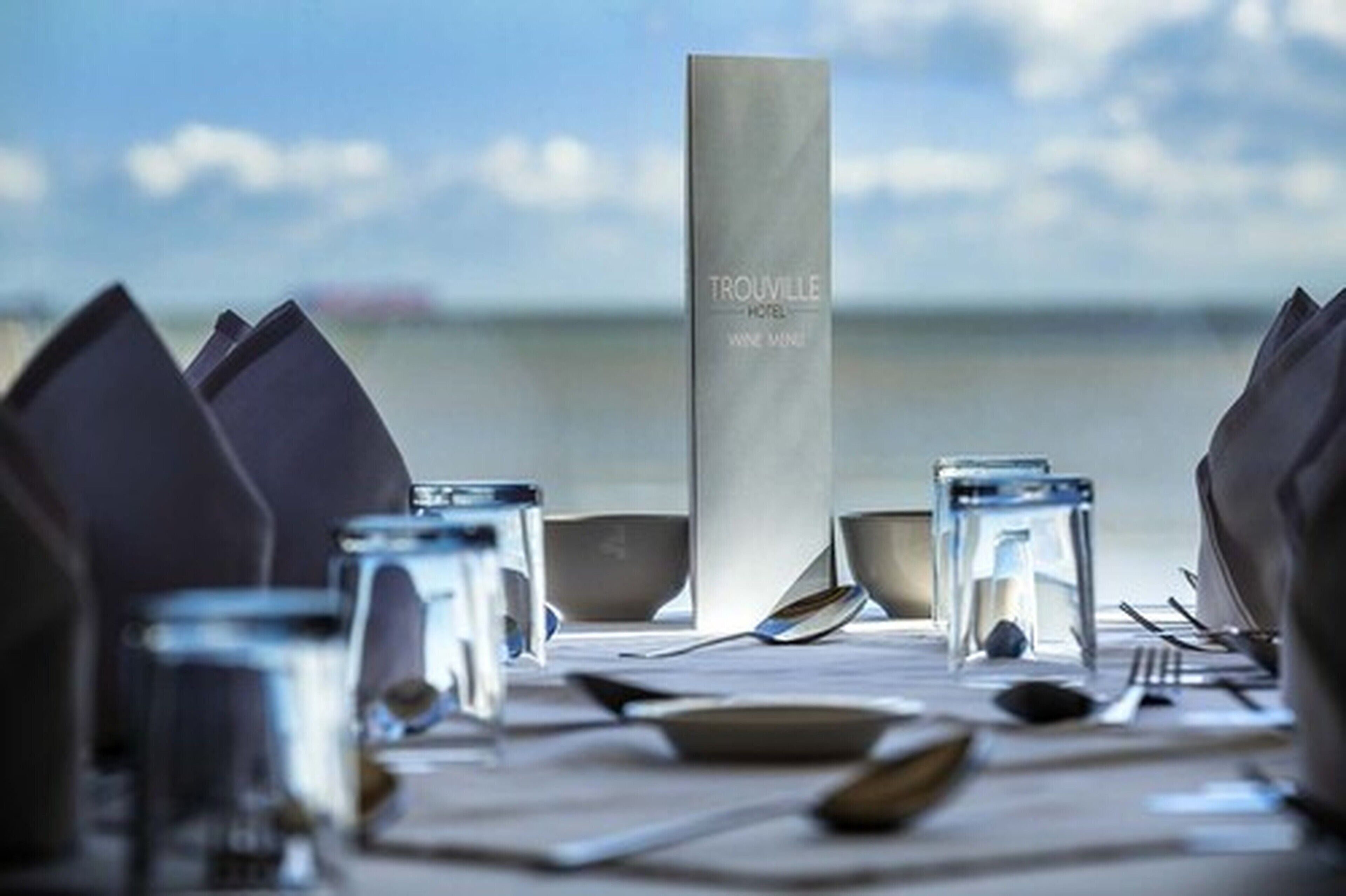 A table set for dining with a menu stand labeled "Trouville Hotel Wine Wine."