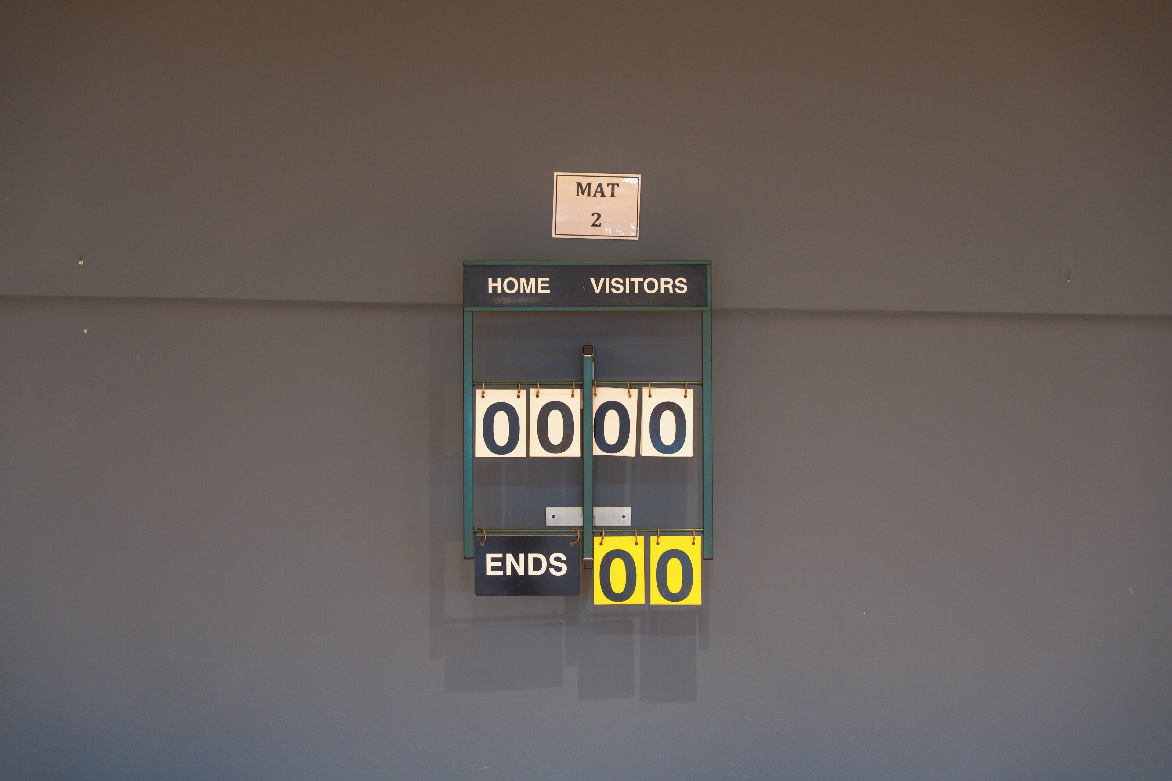 Un tableau d’affichage avec les sections « ÉQUIPE À DOMICILE » et « ÉQUIPE VISITEUSE », une étiquette « MATS 2 » et un indicateur « FIN ».