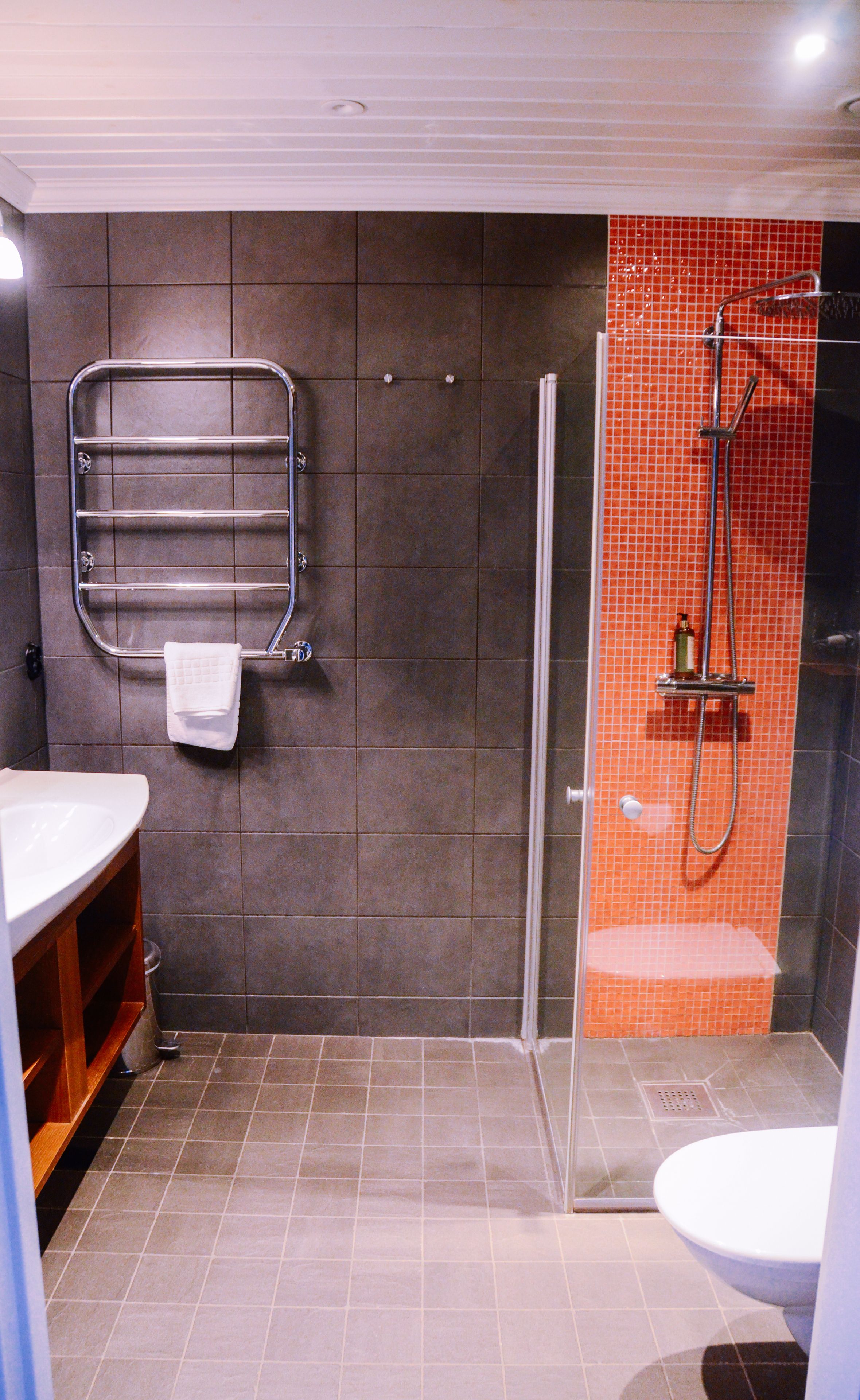 A bathroom with a shower, toilet, and sink.