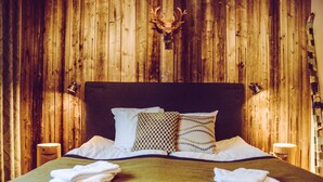 Una cama con cabecera de madera, dos almohadas y dos lámparas de noche.