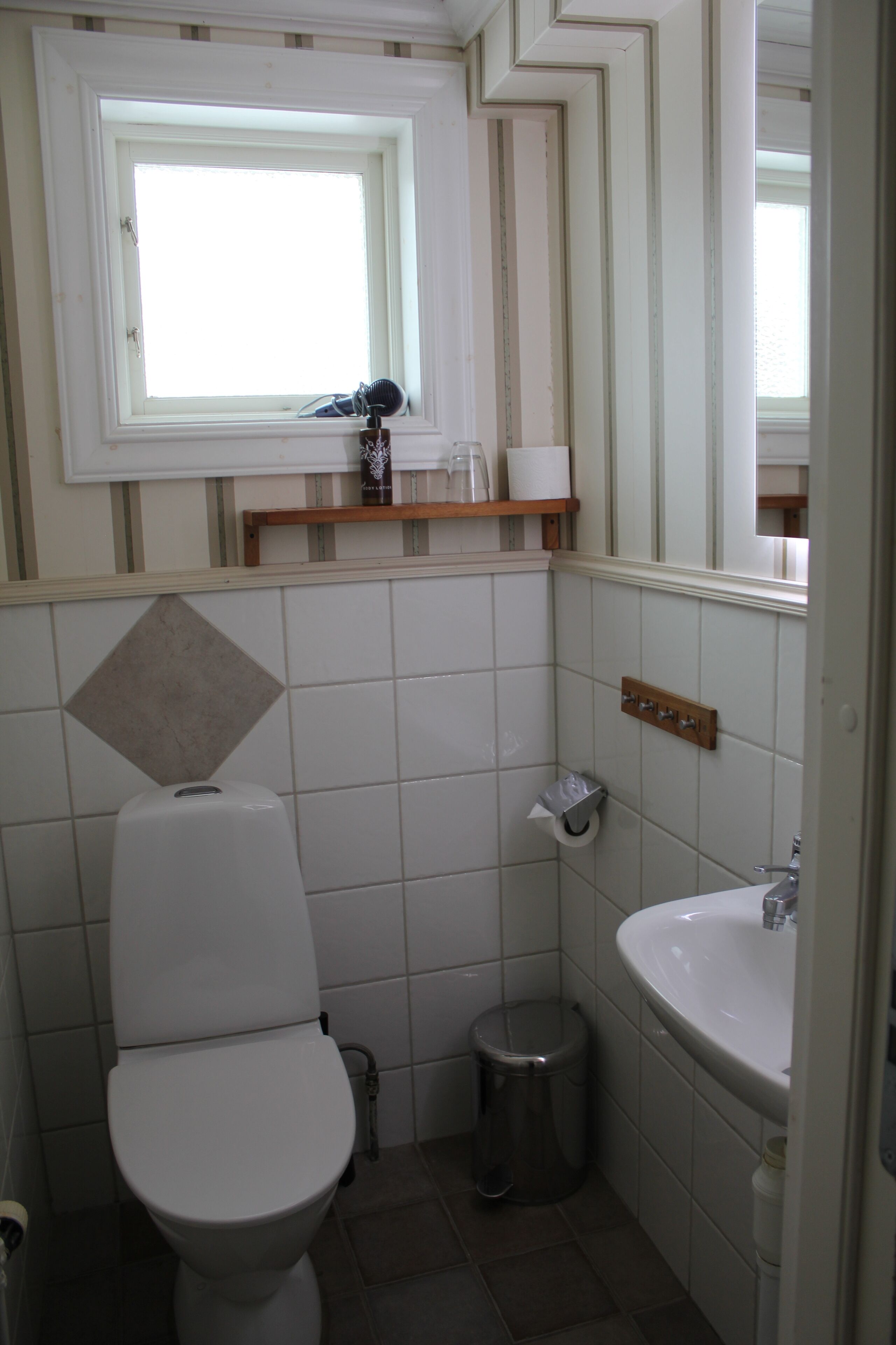 A small bathroom with a toilet, sink, and mirror.