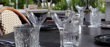 A table set with clear glassware and cutlery, indicating a formal dining arrangement.